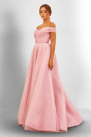 A woman wearing a simple pink gown 
Avoid heavy layers; they can overwhelm your frame.
