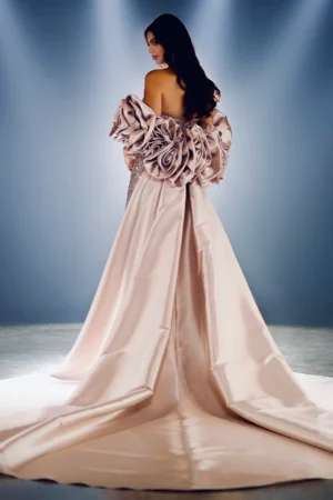 A woman wearing a light champagne-colored floral cape gown 