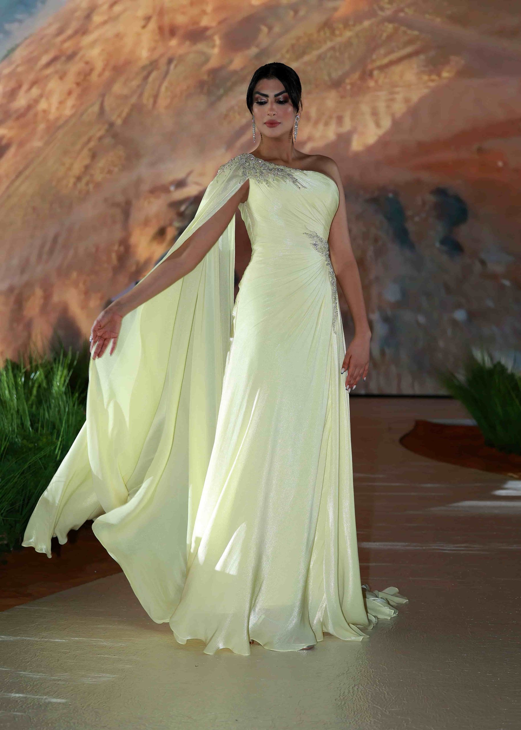 Elegant woman in a yellow gown on the Dubai runway